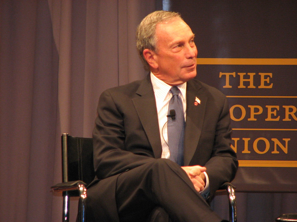Michael Bloomberg seated during a presentation at The Cooper Union.