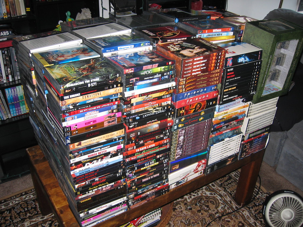 A large collection of DVDs stacked together.