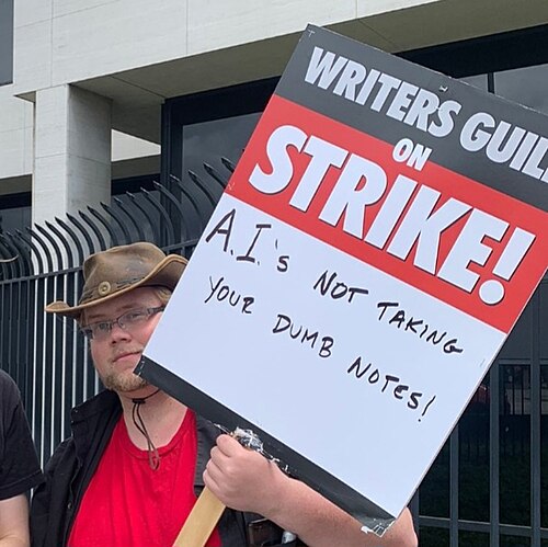A picketer at the 2023 Writers Guild of America strike holds an anti-AI sign.