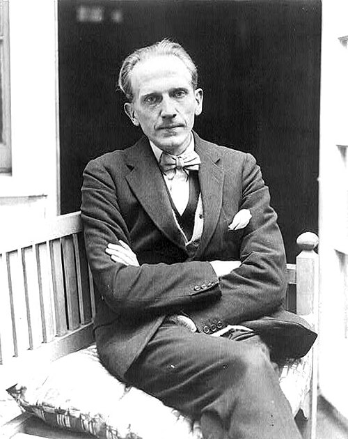 A. A. Milne seated outdoors in 1922.