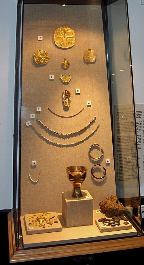 Egyptian jewelry and gold artifacts displayed in a museum exhibit.